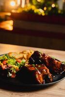 Lunch featuring a steak filet, salad, and French fries, elegantly presented on a table. photo
