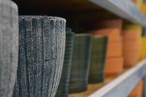 various empty pots for home flower on the store shelf are in a row . High quality photo