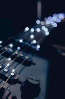 Abstract photo of an electric guitar and its parts macro photo. Music wallpaper and banner for string music album. High quality photo guitar in dark with light reflected in the lacquered surface.