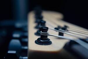 Abstract photo of an electric guitar and its parts macro photo. Music wallpaper and banner for string music album. High quality photo guitar in dark with light reflected in the lacquered surface.
