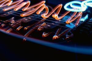 Abstract photo of an electric guitar and its parts macro photo. Music wallpaper and banner for string music album. High quality photo guitar in dark with light reflected in the lacquered surface.