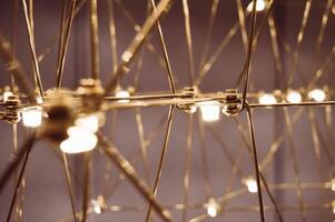 abstract background is a metal structure made of thin rods with light bulbs in a geometric sequence. strange art objects for home and office. High quality photo