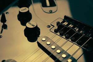 Abstract photo of an electric guitar and its parts macro photo. Music wallpaper and banner for string music album. High quality photo guitar in dark with light reflected in the lacquered surface.