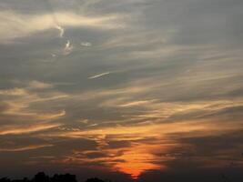 Fiery Sunset over a Silhouetted Landscape photo