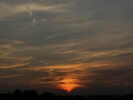 Fiery Sunset over a Silhouetted Landscape photo