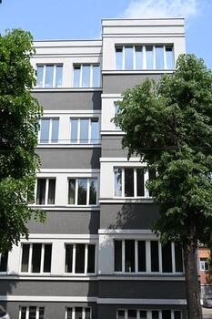 un gris edificio con blanco ventanas y arboles foto
