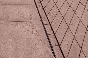 a man is standing on a sidewalk with a skateboard photo