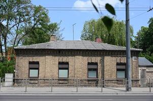 a brick building with a metal fence and trees photo
