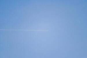 A plane is soaring high while navigating through the clear blue sky photo