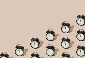 Trendy sunlight pattern made with retro alarm clock on pastel cream background with copy space. Minimal time concept. photo