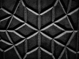 A diamond patterned wall with its textured surface and interplay of light and shadow enhancing the geometric design in picturesque black and white thus reveals intricate details in close ups. photo