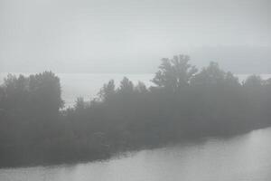 Foggy morning in autumn landscape with lake and mist photo