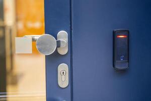Close up view of door with electric lock with reader of entry system mounted on a house wall. High quality photo
