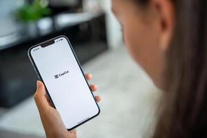 Prague, Czech republic - May 2, 2024. Woman holding iPhone with logo of application CapCut on the screen, using mobile application for business home. High quality photo