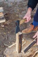 Chopping wood for the fire with an axe. A man's hand with an axe chopping wood. High quality photo