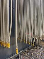 Hanging braided metal hoses with golden connectors in a hardware store. High quality photo