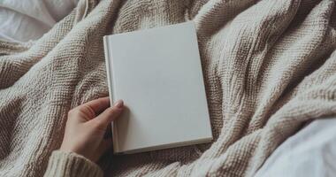 Close-up mockup of woman hands holding a blank white book. Ideal for book cover design, branding, and product display. Minimalist and cozy scene photo