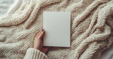 Close-up mockup of woman hands holding a blank white book. Ideal for book cover design, branding, and product display. Minimalist and cozy scene photo
