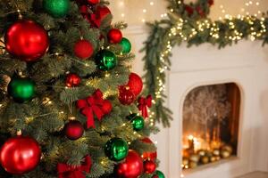 Christmas red bow on a tree, close-up, against the background of a fireplace, stylish New Year photo