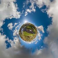 simple little tiny planet without buildings in blue sky with sun and beautiful clouds. Transformation of spherical panorama 360 degrees. Spherical abstract aerial view. Curvature of space. photo
