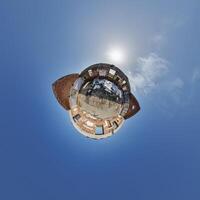 tiny planet in blue sky with clouds of old abandoned ruined church. Transformation of spherical 360 panorama in abstract aerial view. photo