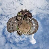 tiny planet in blue sky with clouds of old abandoned ruined church. Transformation of spherical 360 panorama in abstract aerial view. photo