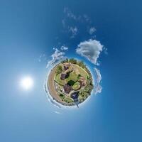 simple little tiny planet without buildings in blue sky with sun and beautiful clouds. Transformation of spherical panorama 360 degrees. Spherical abstract aerial view. Curvature of space. photo