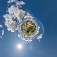 simple little tiny planet without buildings in blue sky with sun and beautiful clouds. Transformation of spherical panorama 360 degrees. Spherical abstract aerial view. Curvature of space. photo