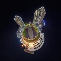 abstract swirling tiny planet spherical panorama of multi-storey buildings of skyscrapers of a residential complex in the form of a butterfly, bugs, crabs in night sky photo