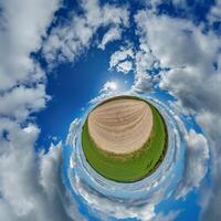 simple little tiny planet without buildings in blue sky with sun and beautiful clouds. Transformation of spherical panorama 360 degrees. Spherical abstract aerial view. Curvature of space. photo