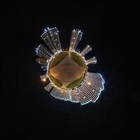 abstract swirling tiny planet spherical panorama of multi-storey buildings of skyscrapers of a residential complex in the form of a butterfly, bugs, crabs in night sky photo