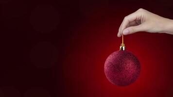 Copy space animation with 2025 symbol on red New Year ball in a hand. On red Background motion animation video