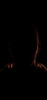 Dark human face with half illuminated by orange light and lightning effect creating a dramatic 3D visual in seamless loop animatio video