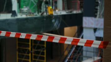 Construction site, with its scaffolding and other equipment, is surrounded by red and white safety barrier to prevent anyone from accidentally getting injured or falling. Close up. video