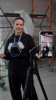 Process of recording a blog about architecture and construction by young and attractive woman, filmed on her smartphone using tripod. video