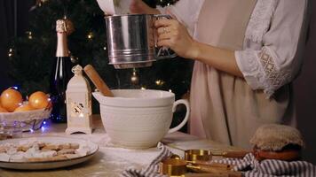 Cook sifts flour through special sieve to mix it and begins preparing dough for New Year's cookies or cake, with ginger or cinnamon. video