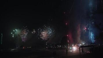 New Year Eve Fireworks Display on Bali Beaches and Silhouette of People Celebrating it in Slow Motion video