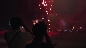 New Year Eve Fireworks Display on Bali Beaches and Silhouette of People Celebrating it in Slow Motion video