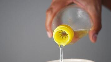 Pouring a generous amount of Cooking Oil into a Bowl for Culinary Preparation video