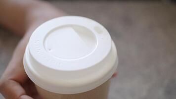An Intimate CloseUp View of a Coffee Cup Lid Being Held by a Gentle Hand video