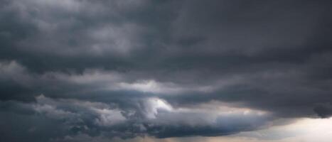 Bad or moody weather sky and environment. the dark sky with heavy clouds converging and a violent storm before the rain. carbon dioxide emissions, greenhouse effect, global warming, climate change. photo