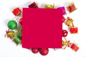 Christmas decorations and red paper on white background photo