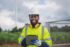 man in a yellow safety jacket is smiling and holding a tablet photo