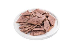 Corned Boiled and sliced beef meat with spices and herbs on a plate isolated on white background photo