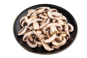 Sliced champignons Mushrooms in a plate isolated on white background. photo
