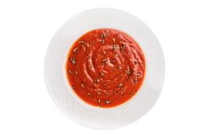 Tomato soup with thyme in plate isolated on white background. top view photo