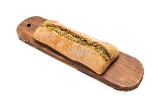 Garlic bread with herbs on wooden cutting board isolated on white background photo