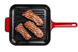 Grilled Tri tip steaks, marbled beef meat on pan with herbs isolated on white background photo