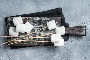 Marshmallow on the stick ready for BBQ. Gray background. Top view photo