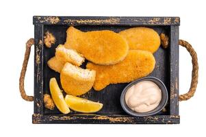 Crusted Fish sticks fingers with lemon and tartar sauce in wooden tray isolated on white background. top view photo